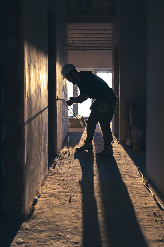 worker is cutting wires with lineman's pliers.